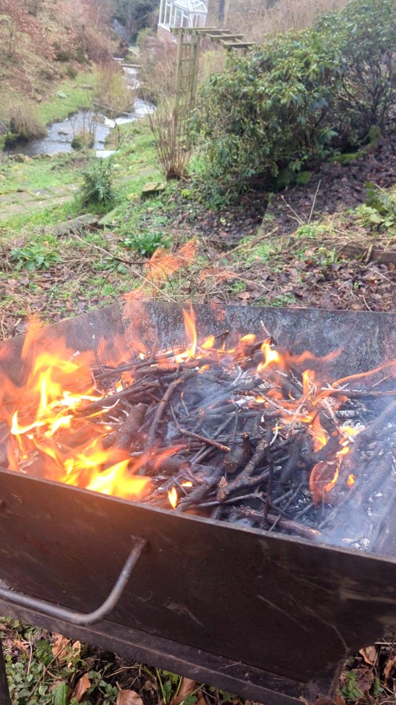 A fire burning in a steel biochar kiln